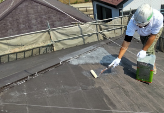 屋根に下塗りしていく様子