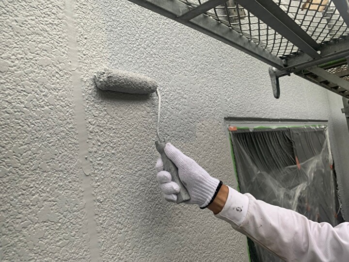 外壁を中塗り後に上塗りする作業風景