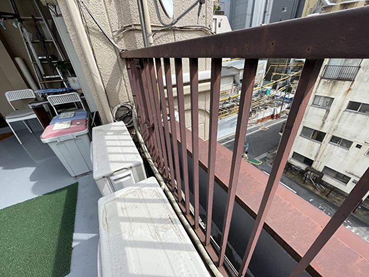 鉄製の手摺を点検している作業風景