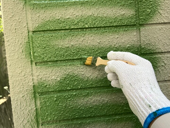 まず刷毛で溝の周囲を丁寧に塗装する作業風景