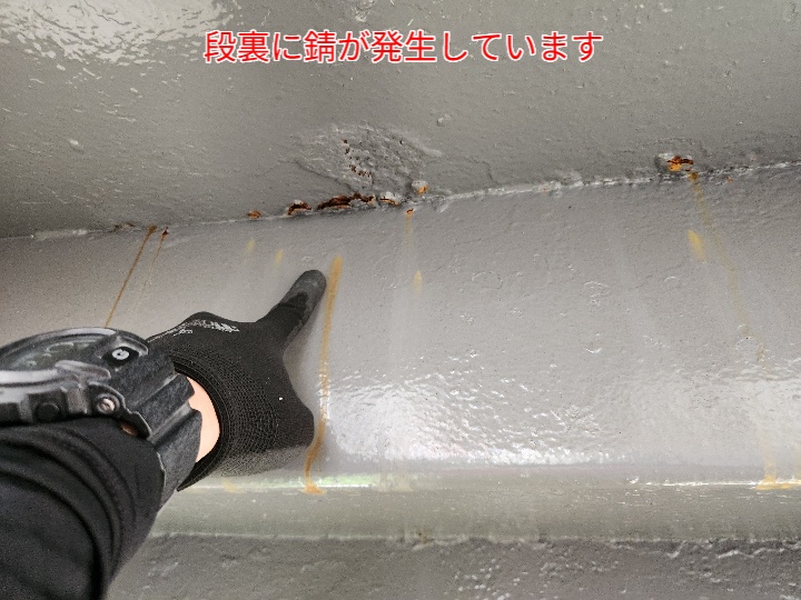 段裏の錆を指さしで示す写真。点検と防錆塗装を早急に行いましょう。