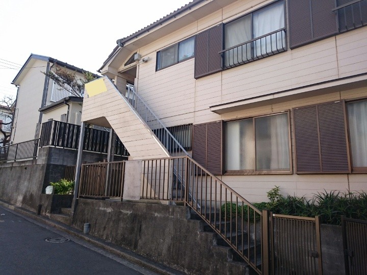 退色や苔が繁殖したアパート外壁